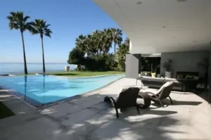 Luxurious villa in Marbella with a stunning infinity pool overlooking the ocean, ideal for selling or renting through Rainbow Realty.